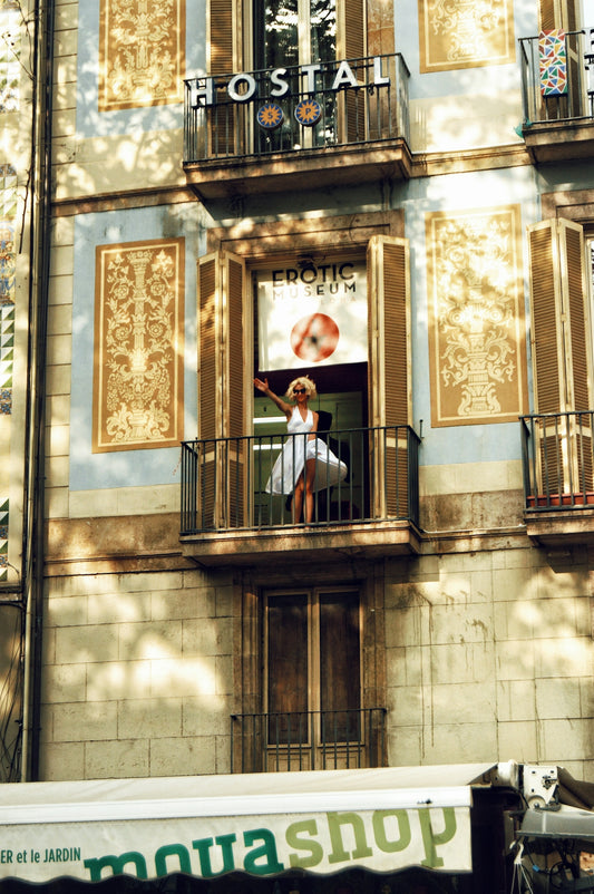 woman waving her right hand on building balcony during day