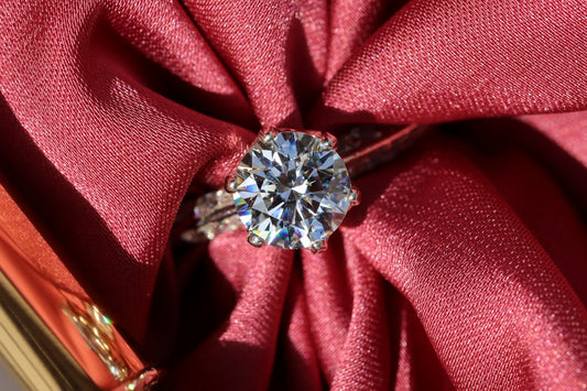 silver diamond ring on red textile