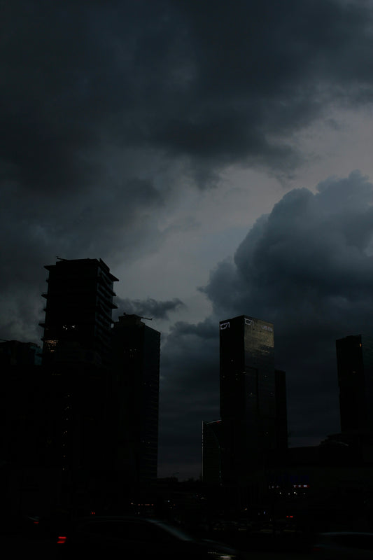 dark clouds loom over a city at night