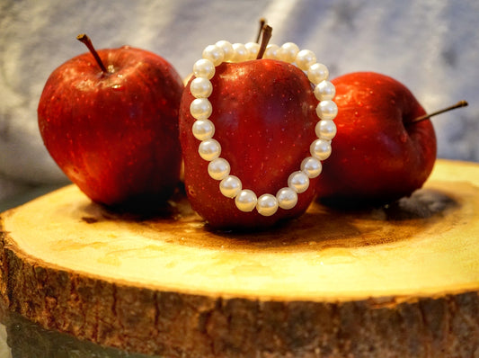 a couple of apples sitting on top of a piece of wood
