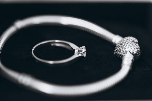 A silver ring with a white bead on it